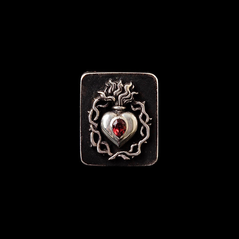 Sacred Heart Ring with a red garnet on a black background